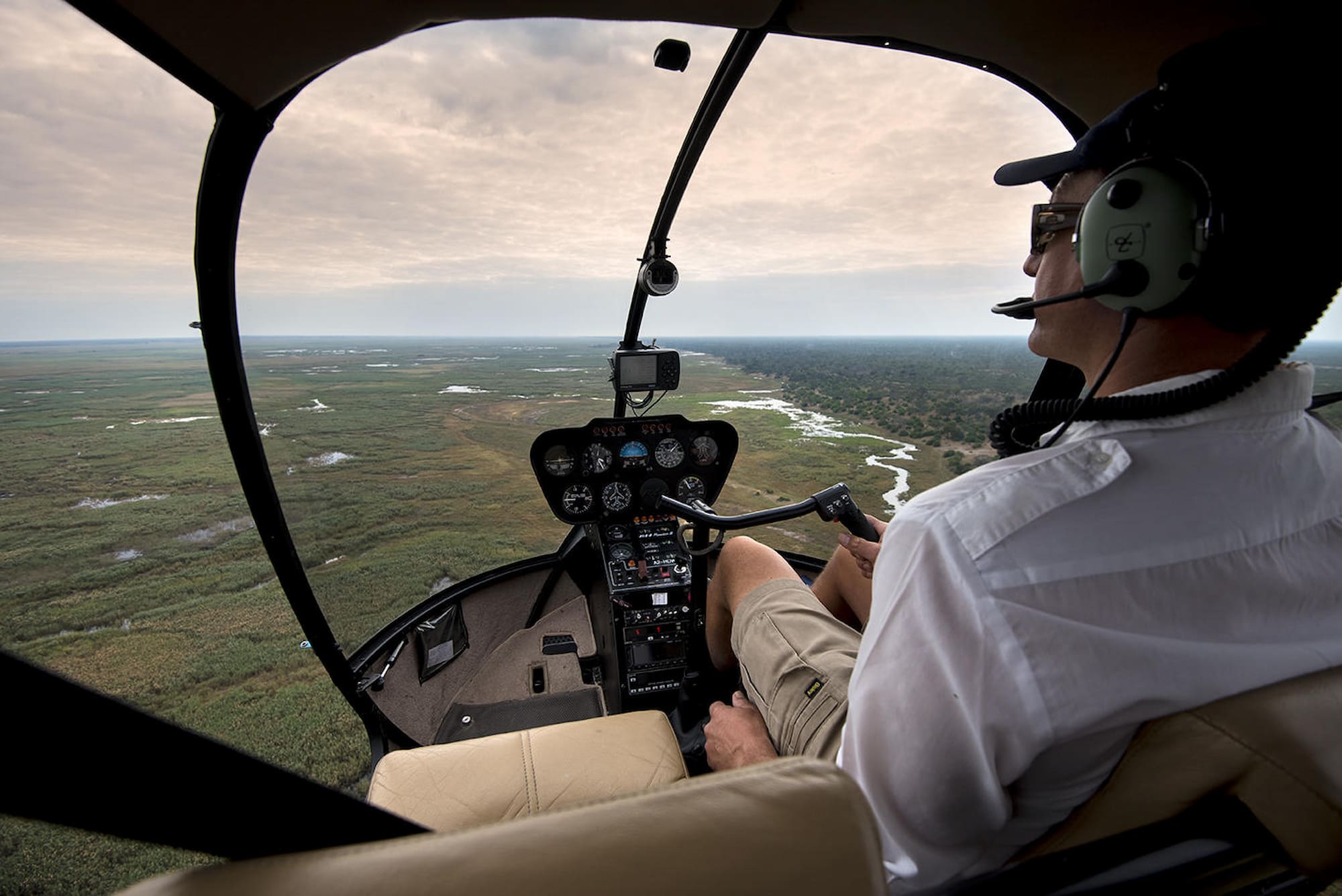 Pilot in helicopter flying to Linyati Bush Camp, Botswana.