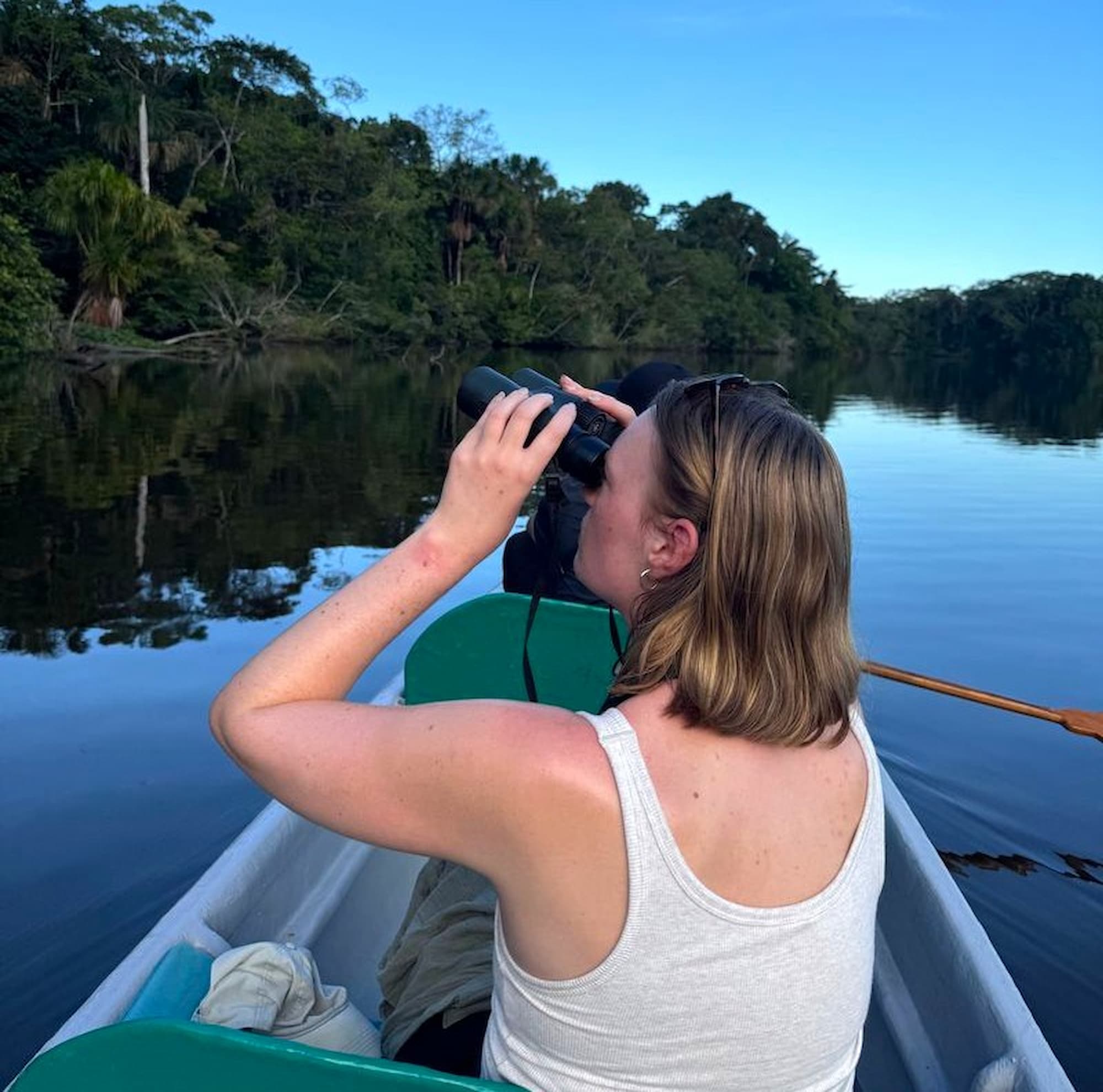 Wildlife watcher with binoculars in Ecuador Amazon rainforest