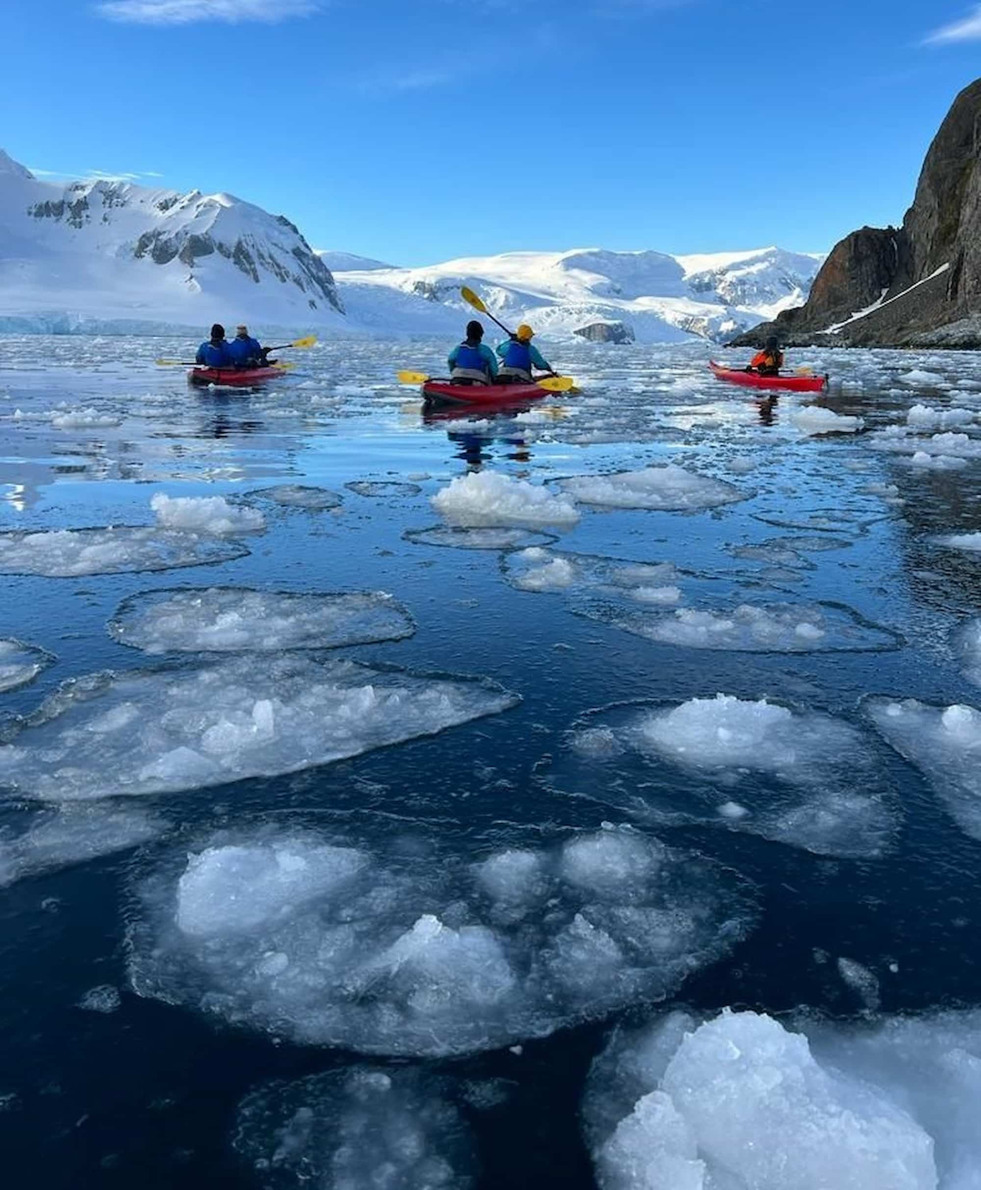 A group of adventurous travelers spend the day paddling and kayaking through Antarctica’s icy waters.