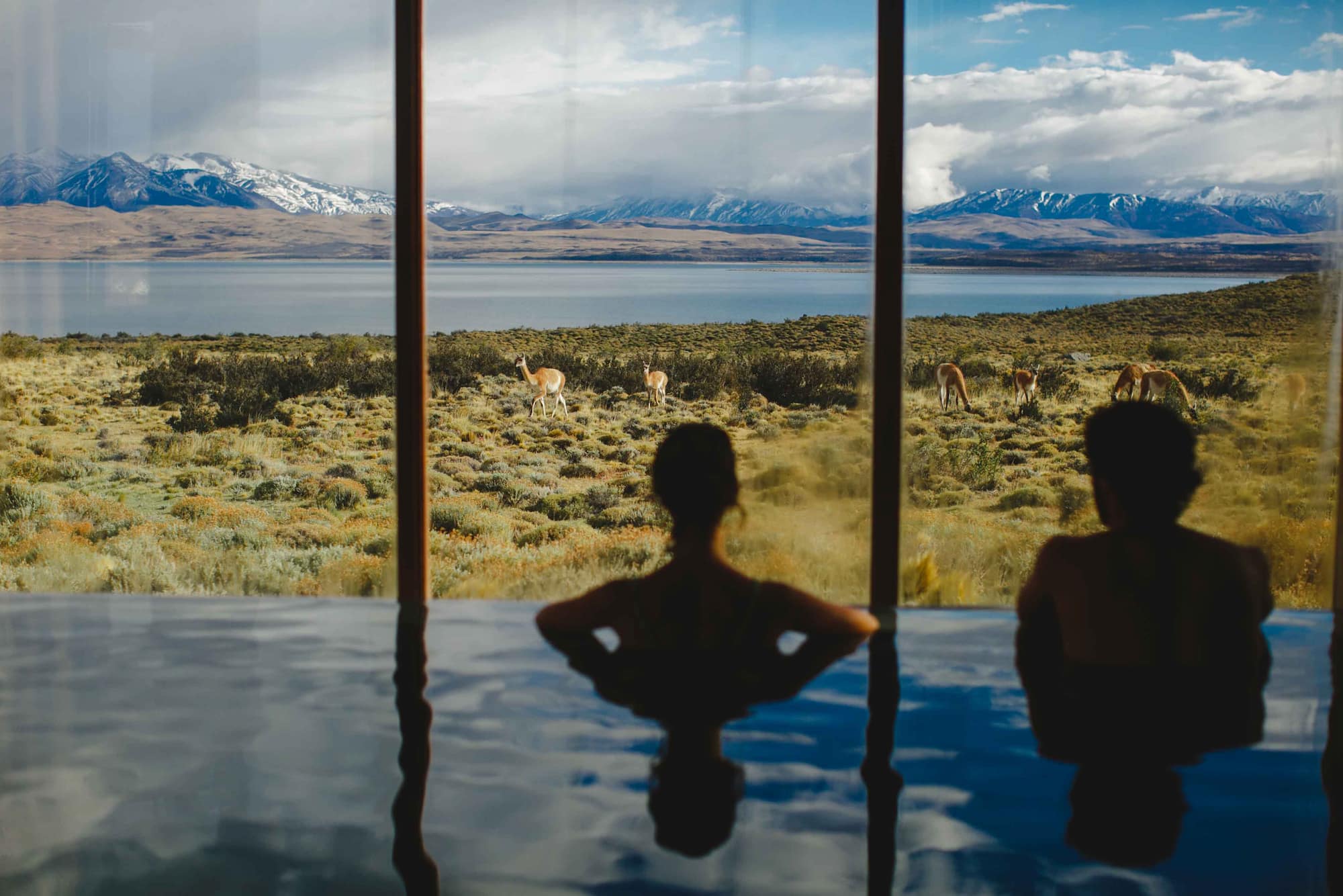 Guests relax in an infinity pool at Tierra Patagonia, overlooking Torres del Paine in Patagonia.