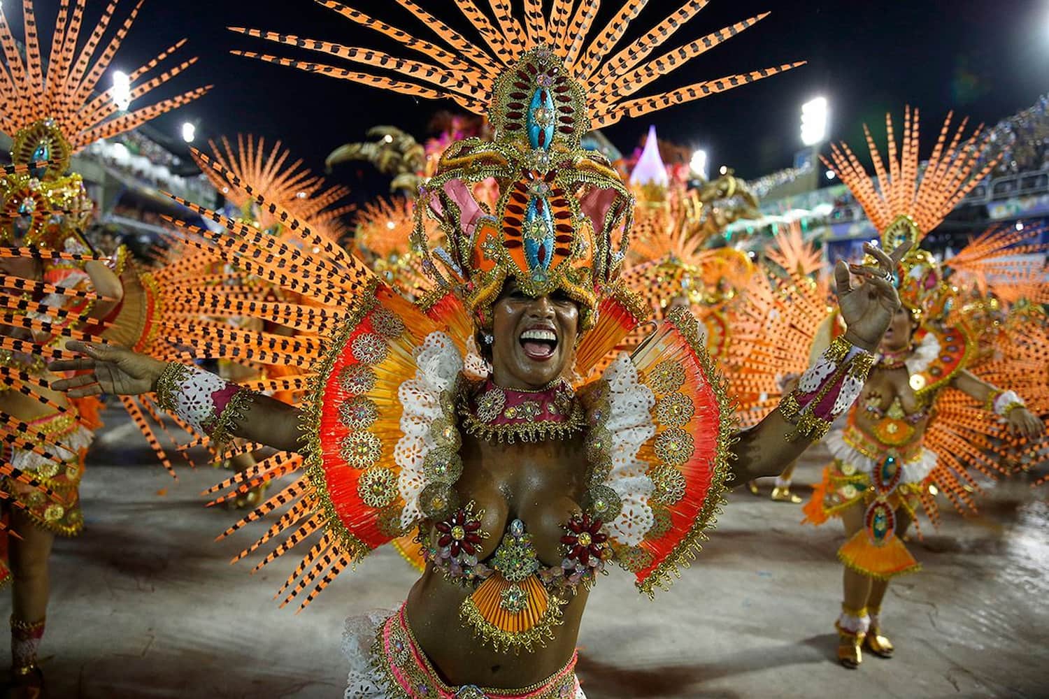 A Carnival dancer in an elaborate orange and gold costume performing in Rio de Janeiro’s Sambadrome.