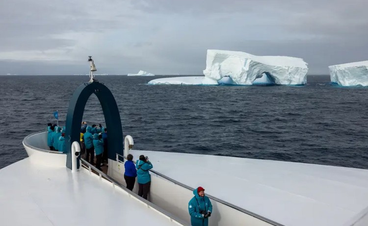 Antarctic cruise guest on ship deck