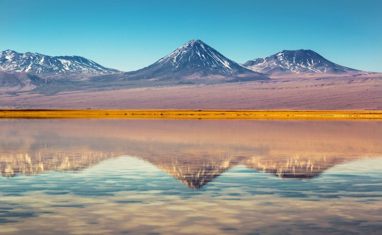 Atacama Desert tour snow capped Licancabur Volcano reflected in the still waters of Laguna Lejia Chile