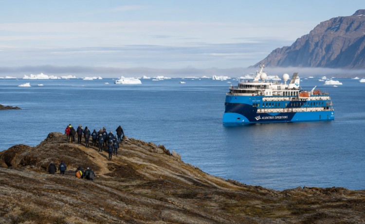 Greenland shore landing with expedition ship in the background