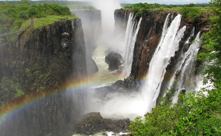 Rainbow over Victoria Falls on Zambezi River border of Zambia and Zimbabwe shutterstock 102089128