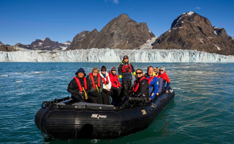 Iceland and East Greenland people on zodiac with glacier on the background