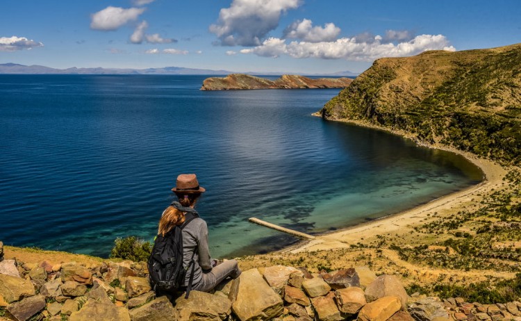 Sun Island Ecolodge hiker gazing out over the turquoise waters of Lake Titicaca
