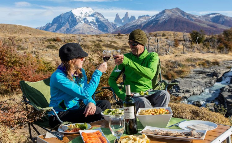 Patagonia Camp tours guest enjoying a meal with stunning mountain landscape
