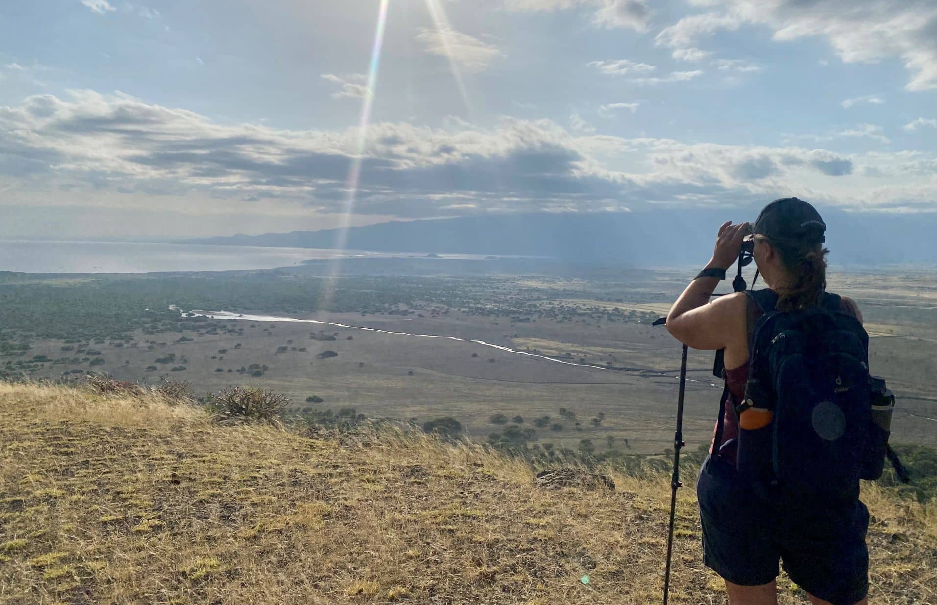 Tanya uses binoculars to take in the sweeping savanna landscape