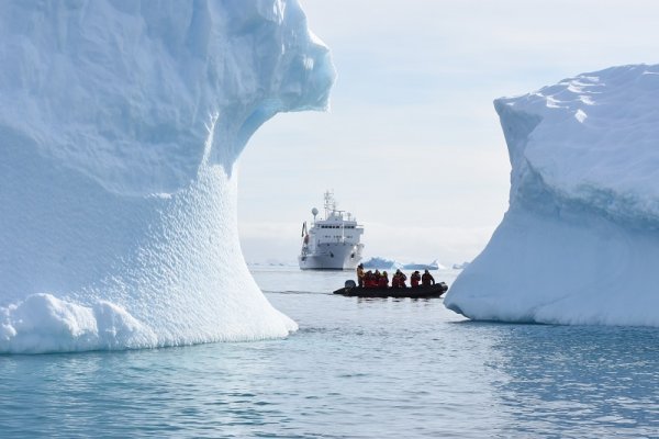 Cruise ship and a zodiac sailing between the glaciers