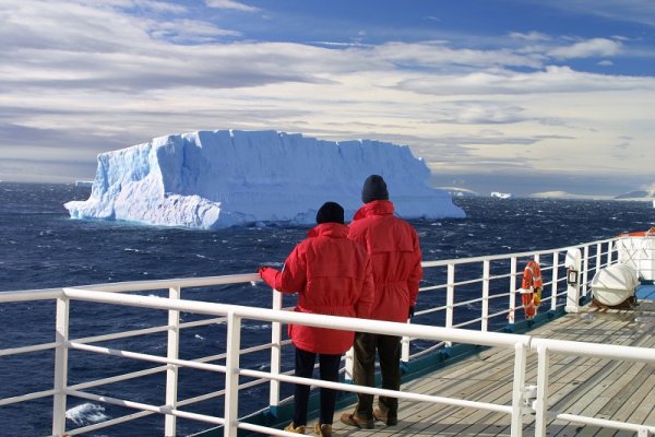 Tourists onboard passing a big glacier