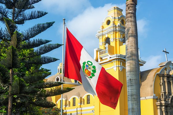 Peruvian flag and yellow church in the Barranco neighborhood in Lima, Peru