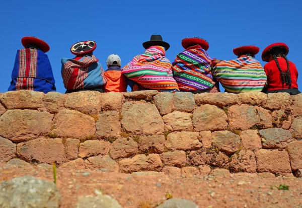 Quechua Ladies and a young boy chatting on an ancient Inca wall, Peru