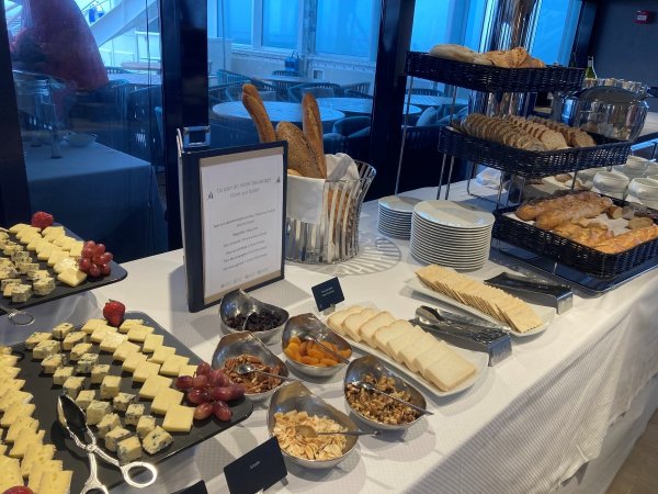 Buffet table filled with cheeses and breads