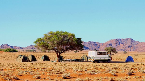 Group of tents and 4x4 offroad safari truck in Namibia