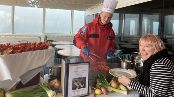 Chef preparing seafood for a passenger on Le Soleal