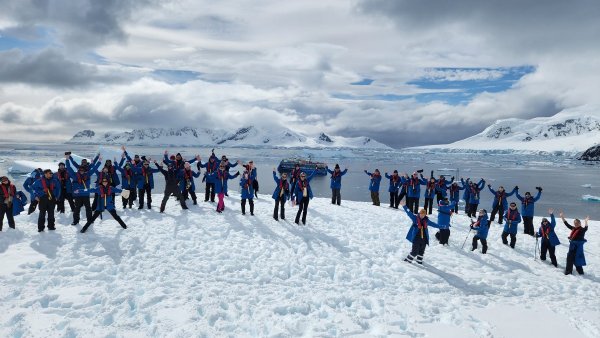 Group of people on the ice in Antarctica, with Ocean Albatros in the background