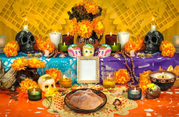 Traditional Mexican Day of the Dead altar with sugar skulls and candles