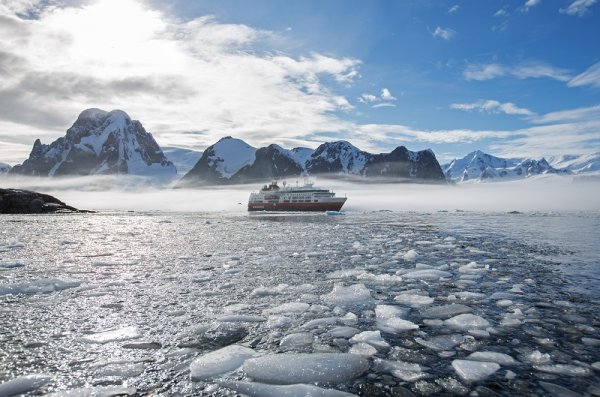 Small Hurtigruten vessel sailing in the icy waters in Antarctica