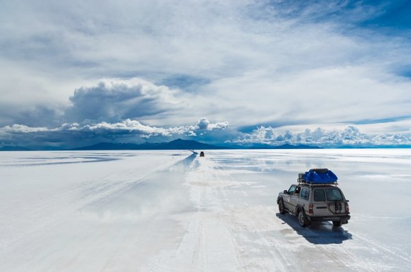 Car driving on salt flats in Bolivia