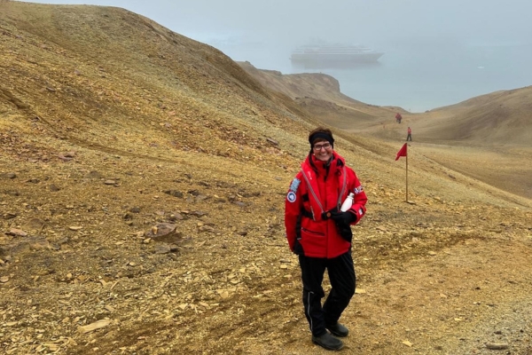 Pia hiking in Greenland, with L'Austral in the background