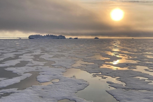 Midnight sun over ice-covered waters in Greenland