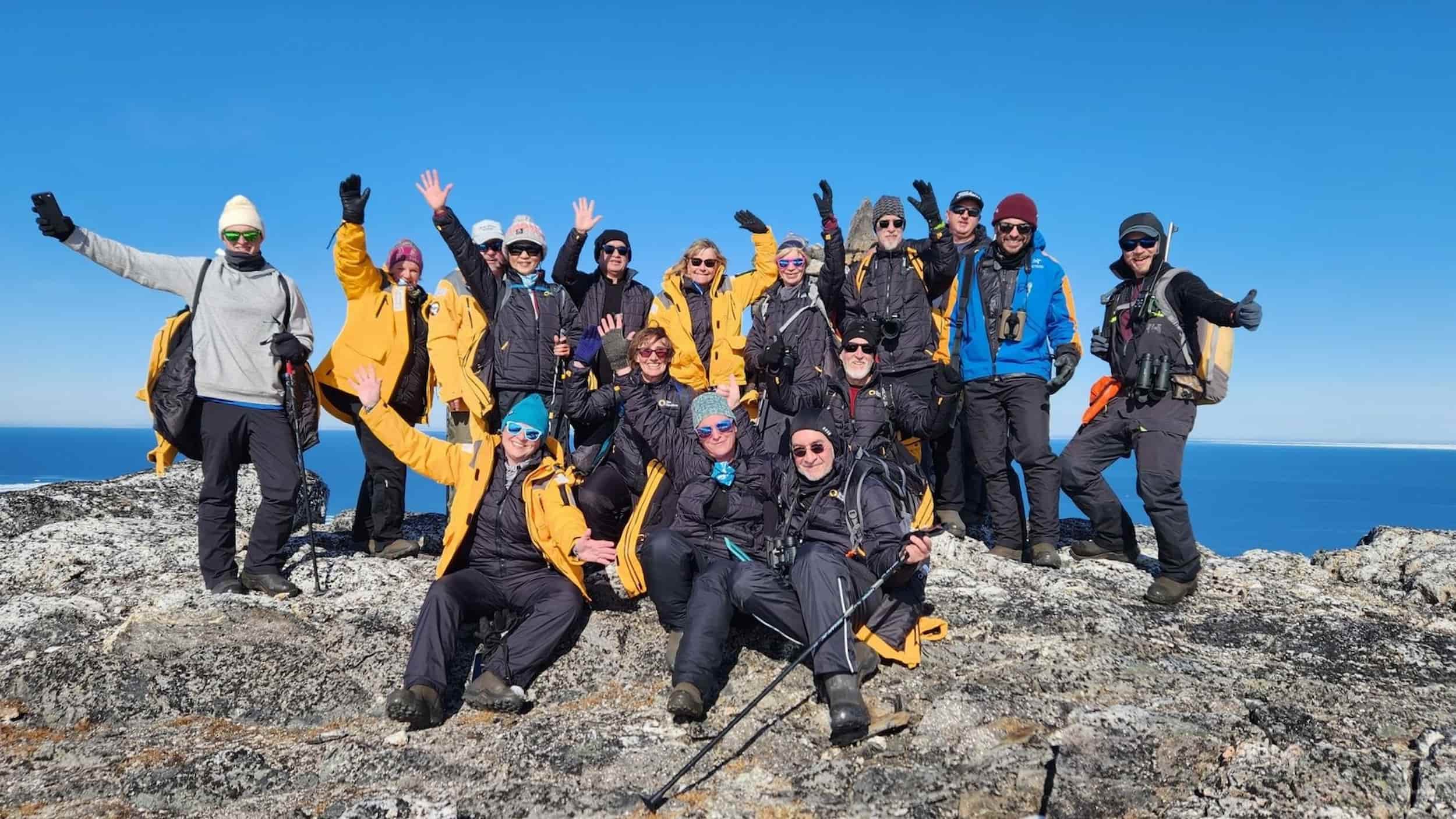 Rach and the other passengers of the Ultramarine pose for a group photo while resting after an Arctic ice safari hike.