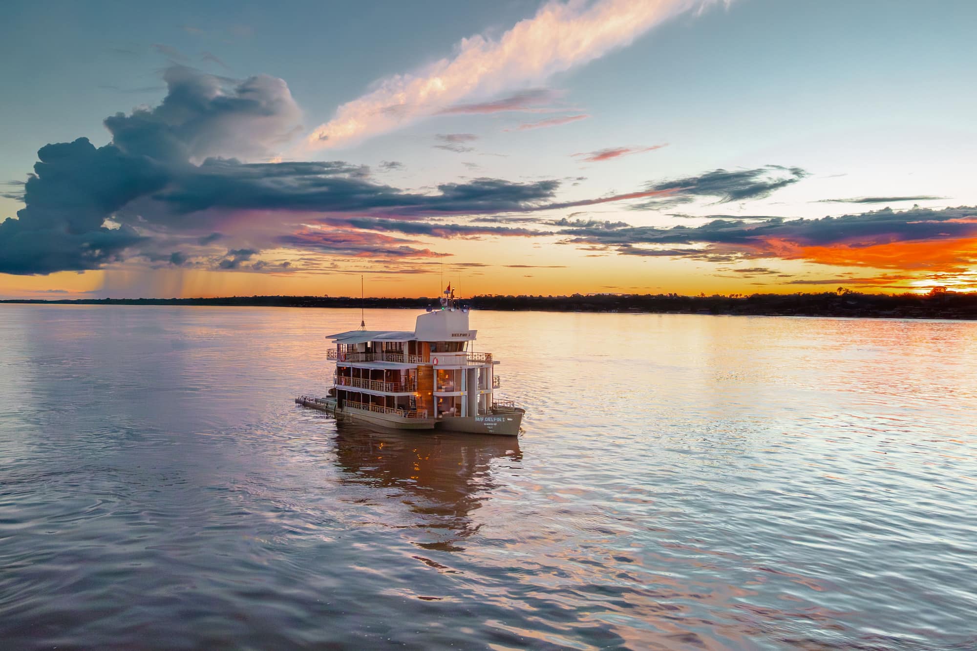 Riverboat cruising through the Amazon rainforest at dusk, Brazil