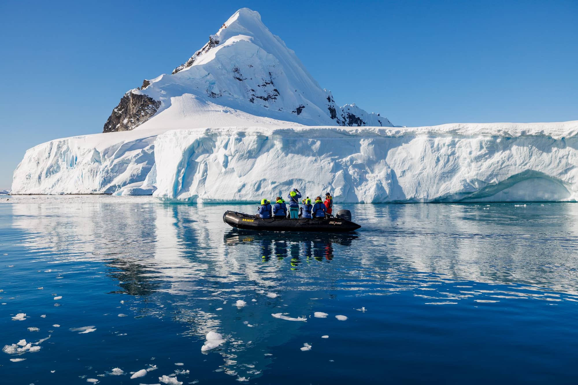 Zodiac boat cruising past penguins in Antarctica on an expedition cruise from the USA.