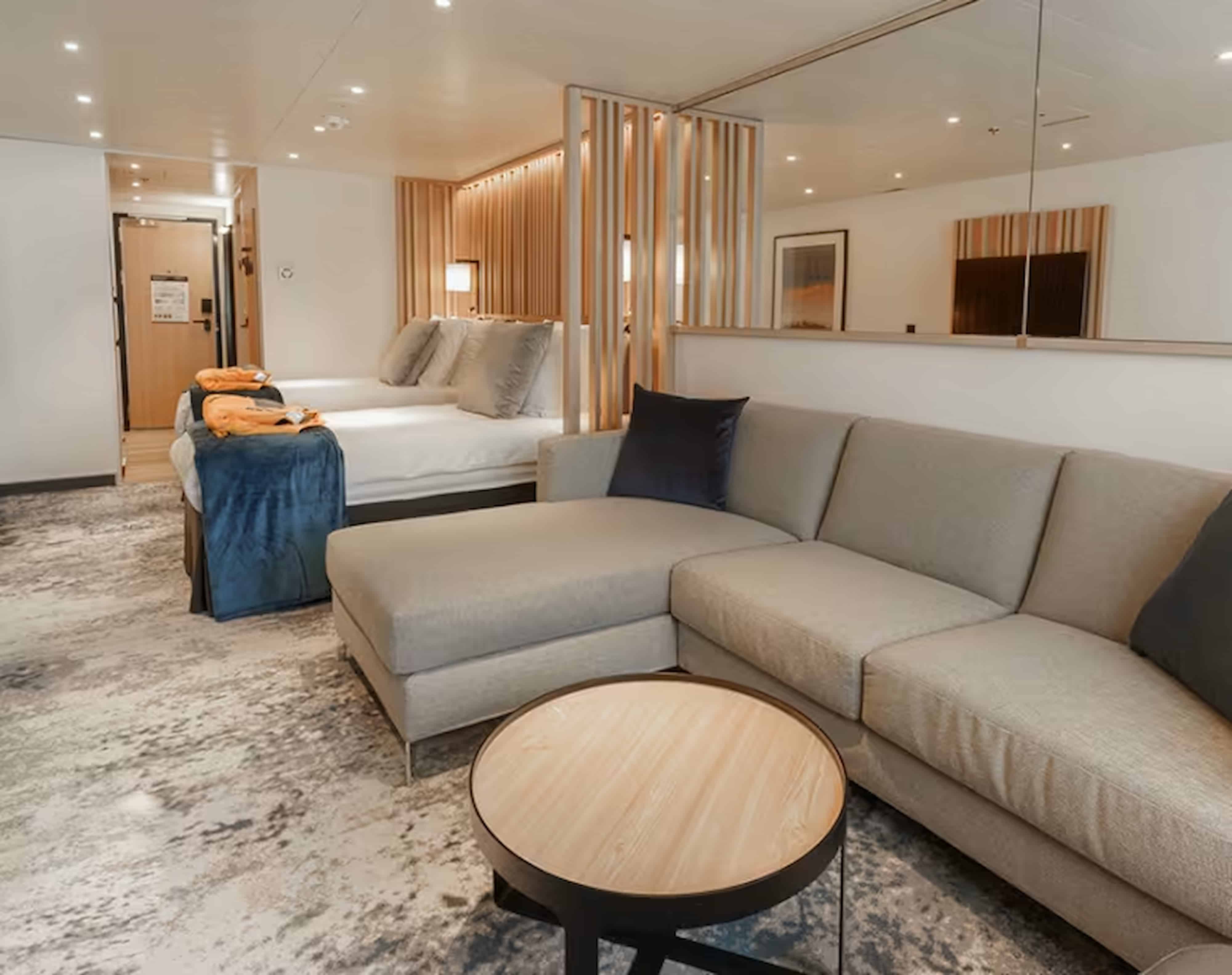 Balcony stateroom on Ultramarine, the lowest-priced balcony cabin, with twin beds, modern design, and floor-to-ceiling windows overlooking the Arctic.