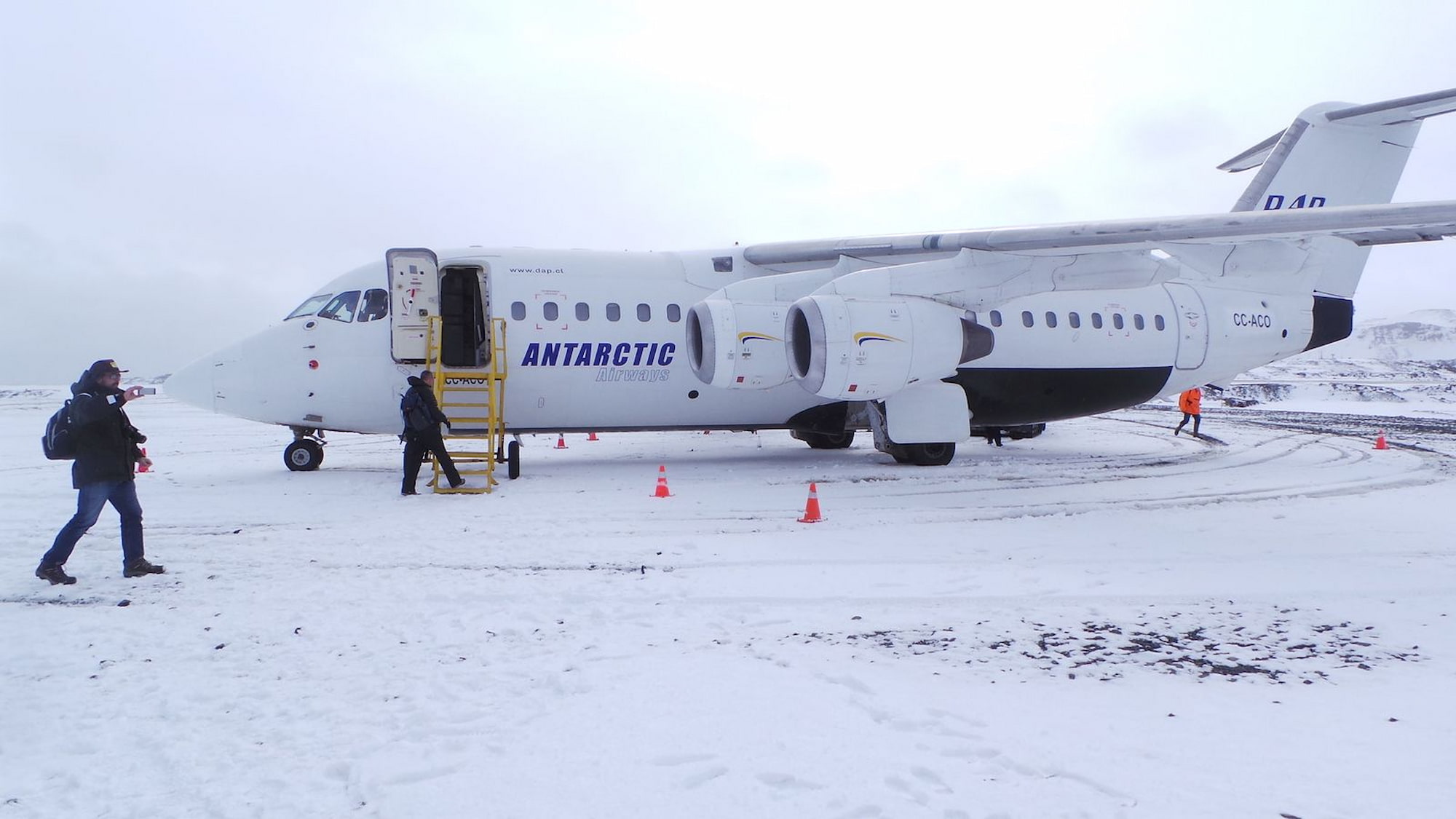 Passengers boarding an Antarctic Airways plane on a snowy runway at King George Island, Antarctica.
