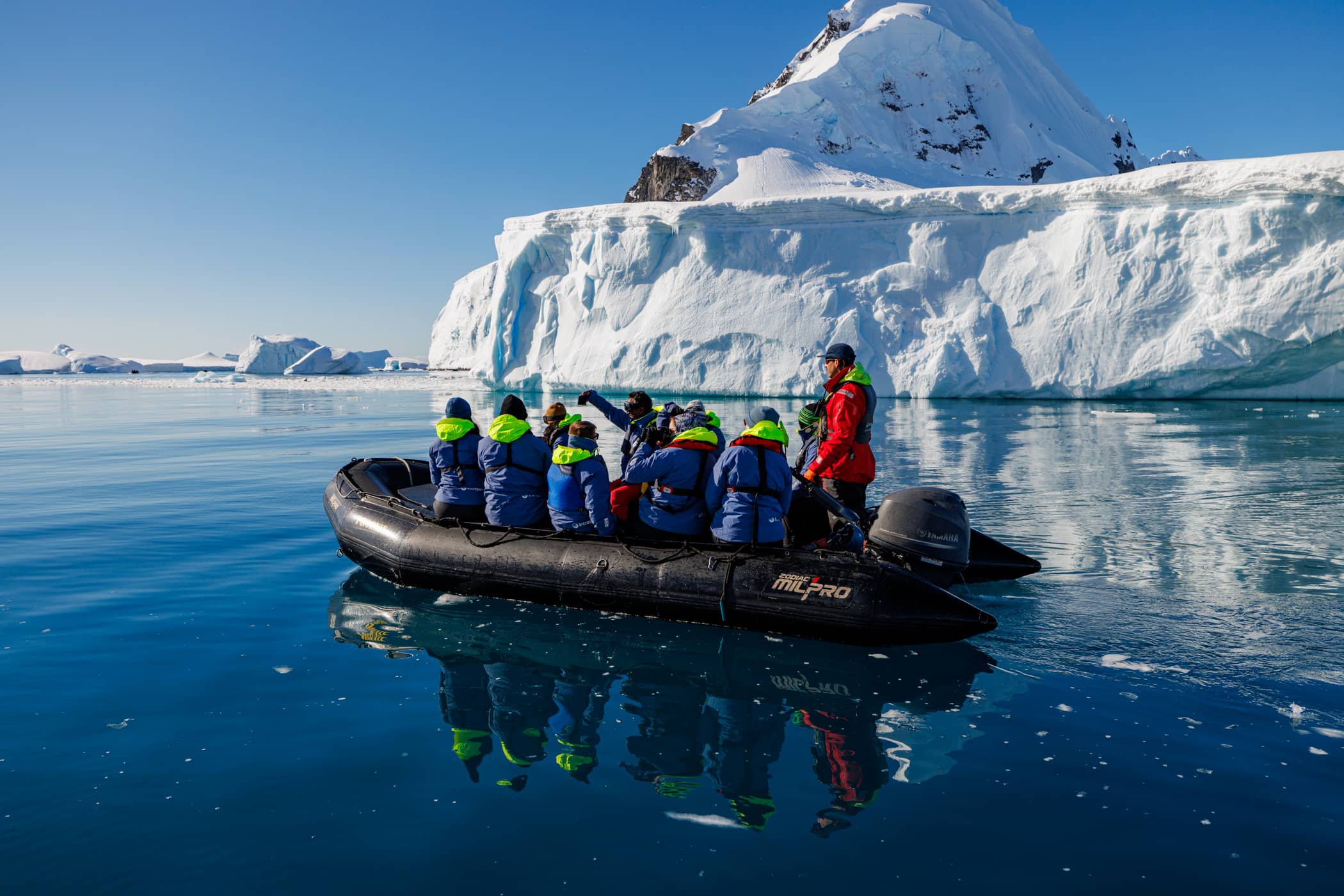 Expedition cruise ship passengers exploring Antarctica on a Zodiac. 