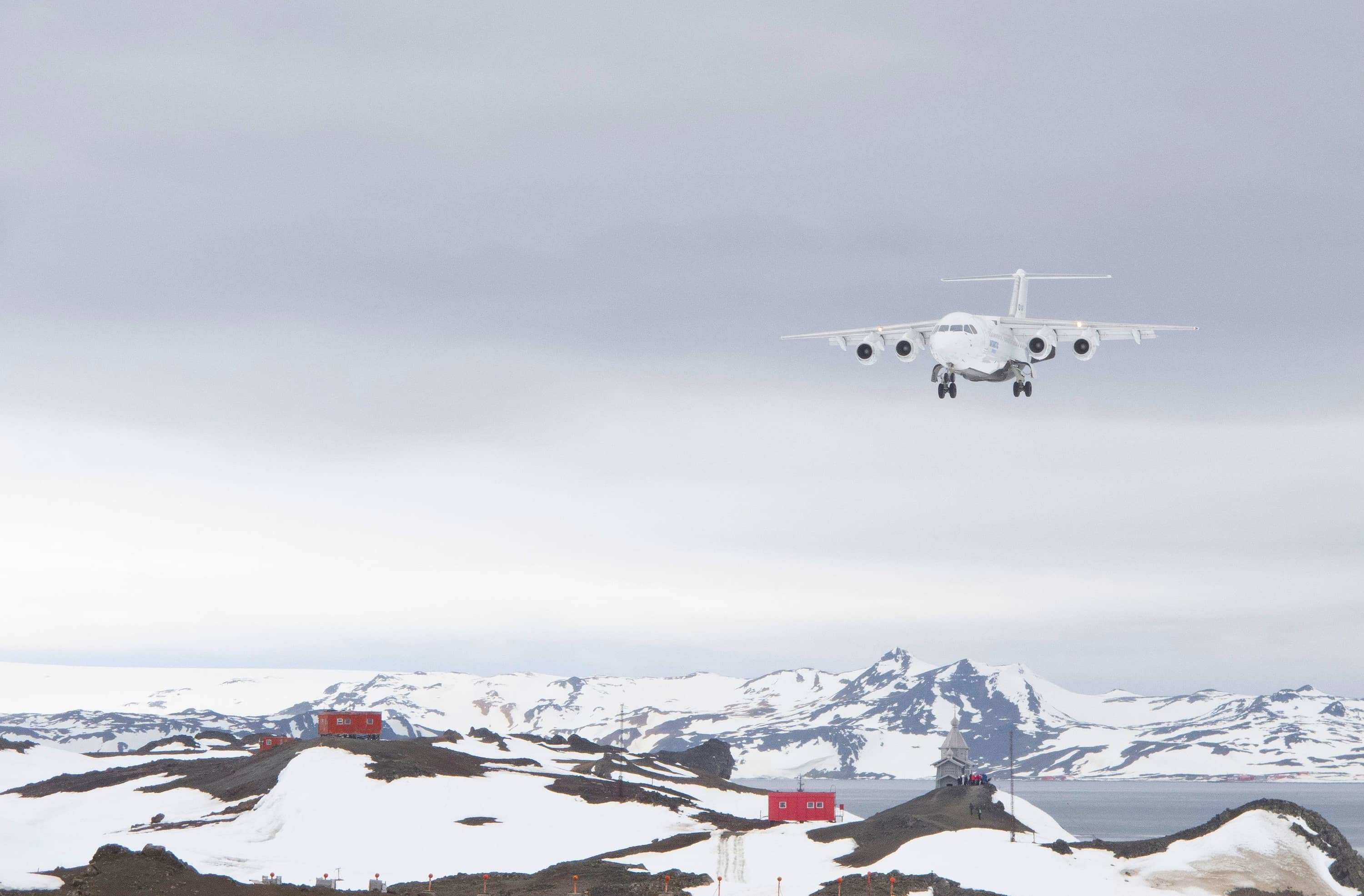 Small plane approaching landing strip on King George Island, Shetland Islands, Antarctica.
