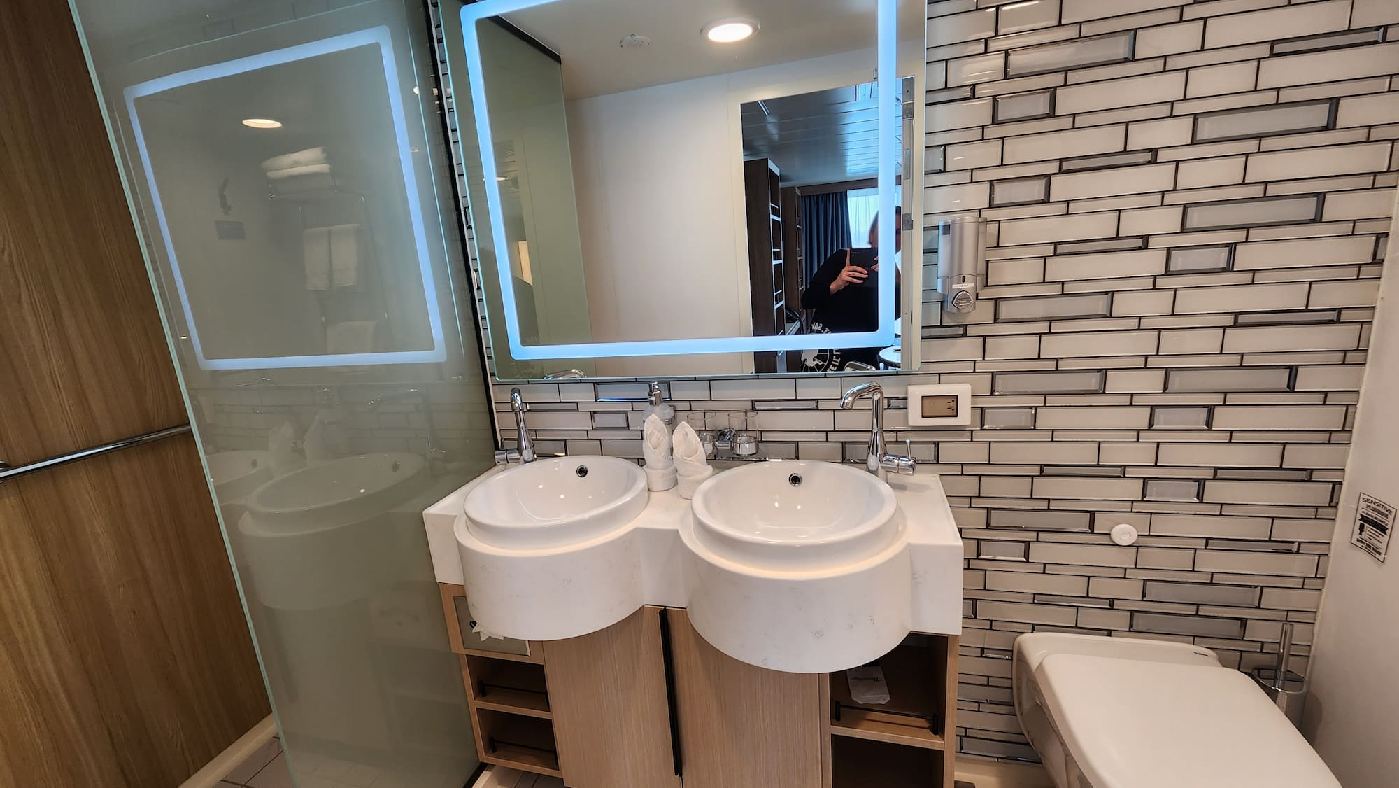 Expedition cruise cabin en-suite, showing his and hers sinks, walk-in shower and luxury fittings.